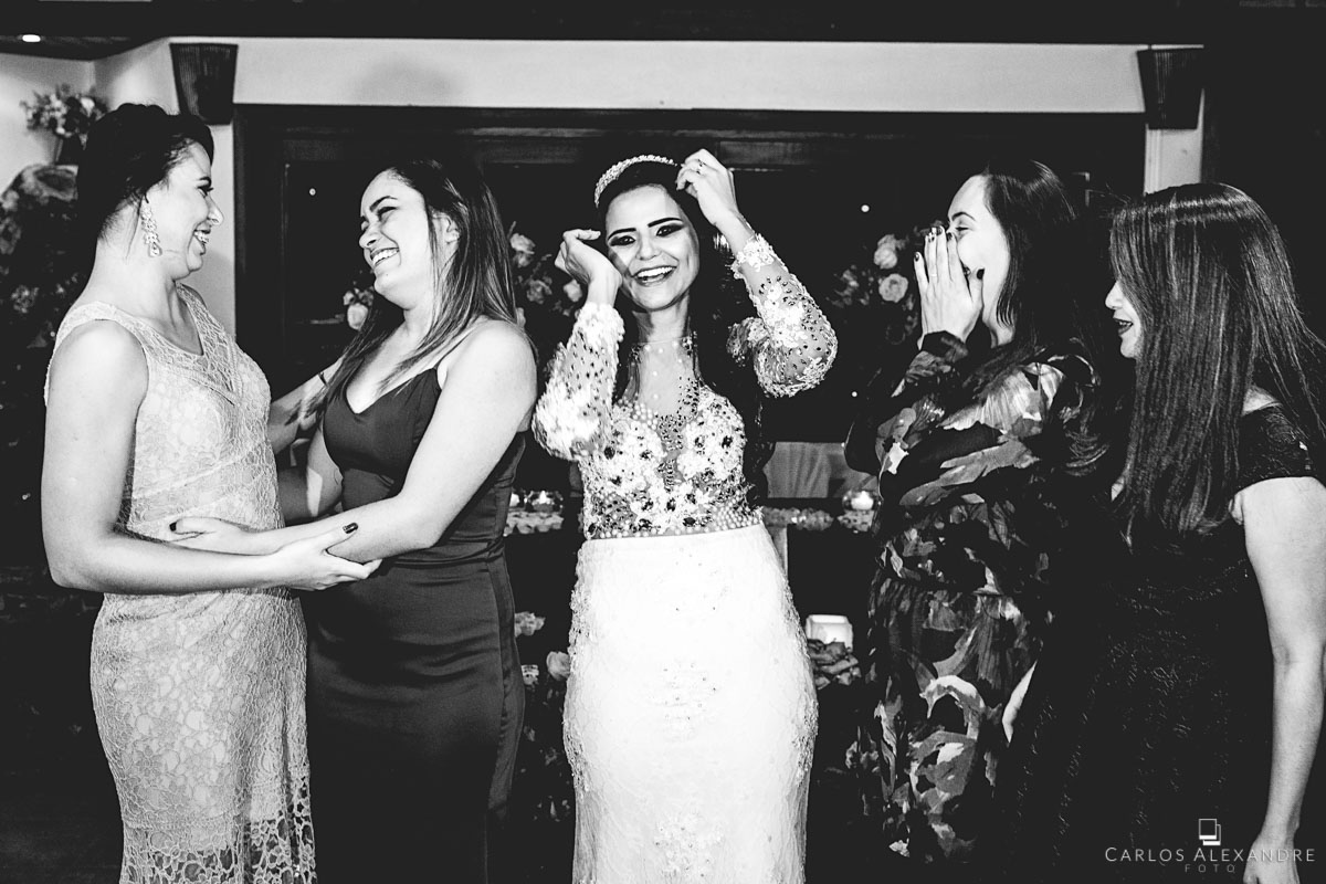 primas e noiva matando a saudade em seu casamento, relembrando e contando histórias de infância fotografado por carlos alexandre foto fotógrafo em três corações sul de minas