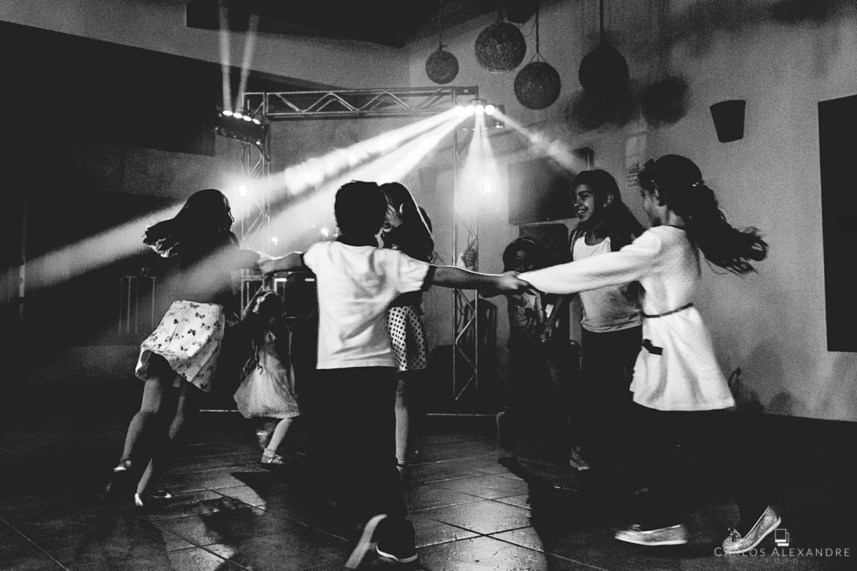 crianças brincando e dançando sorridentes na festa do casamento fotografado por carlos alexandre foto fotografo em tres corações sul de minas em são lourenço