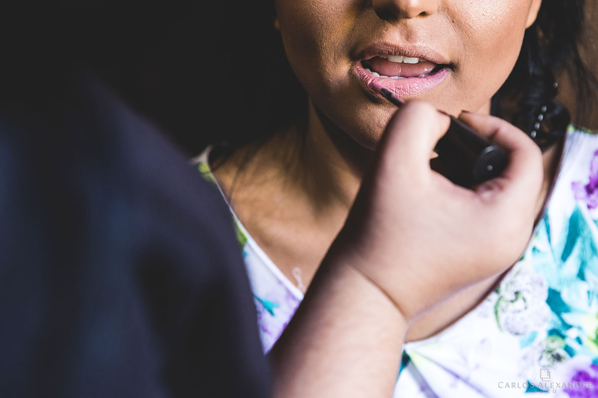 noiva passando batom e se maquiando para o seu casamento fotografado por carlos alexandre foto fotógrafo em três corações sul de minas