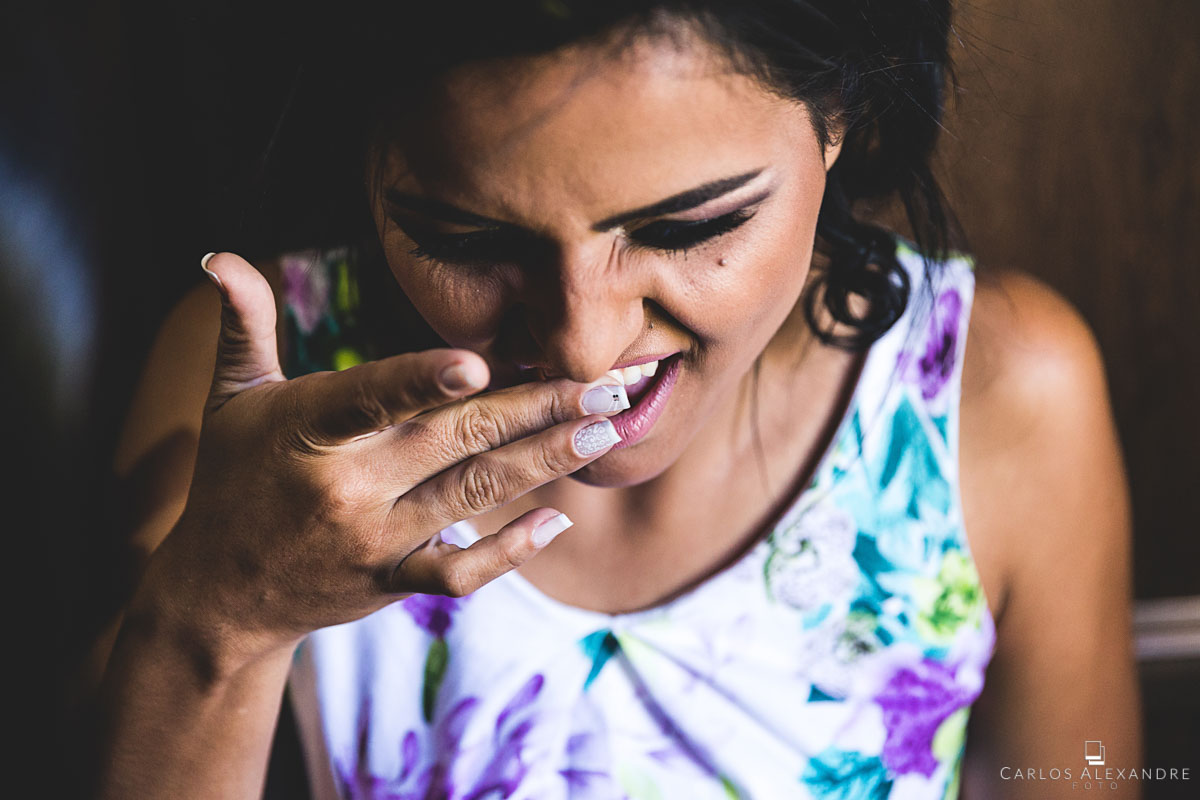 noiva tirando o batom do dente fotografado por carlos alexandre foto fotógrafo em três corações sul de minas