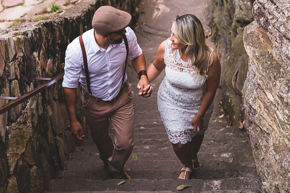 casal caminhando subindo as escadas de mãos dadas em seu ensaio de pré casamento em são thomé das letras MG fotógrafo em três corações carlos alexandre foto