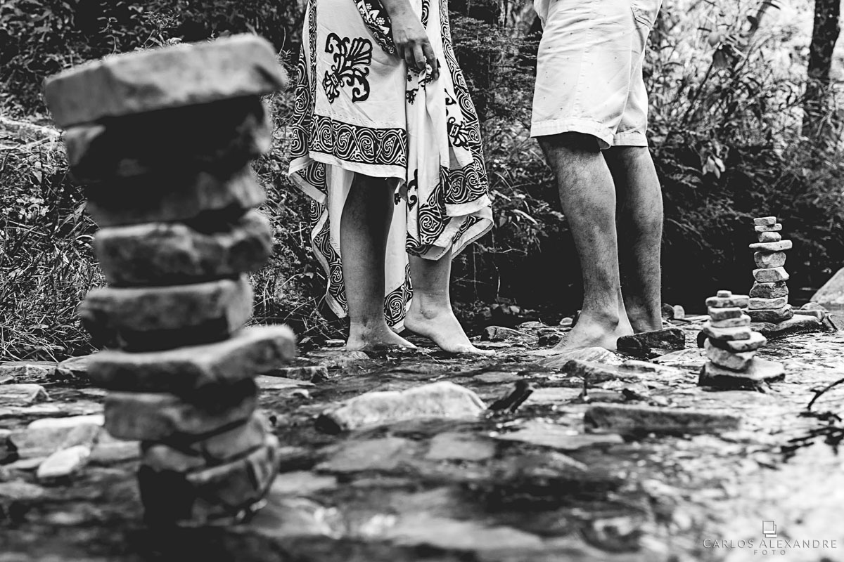 toten e pés do casal com água sobre os dedos  em seu ensaio de pré casamento em são thomé das letras MG fotógrafo em três corações carlos alexandre foto