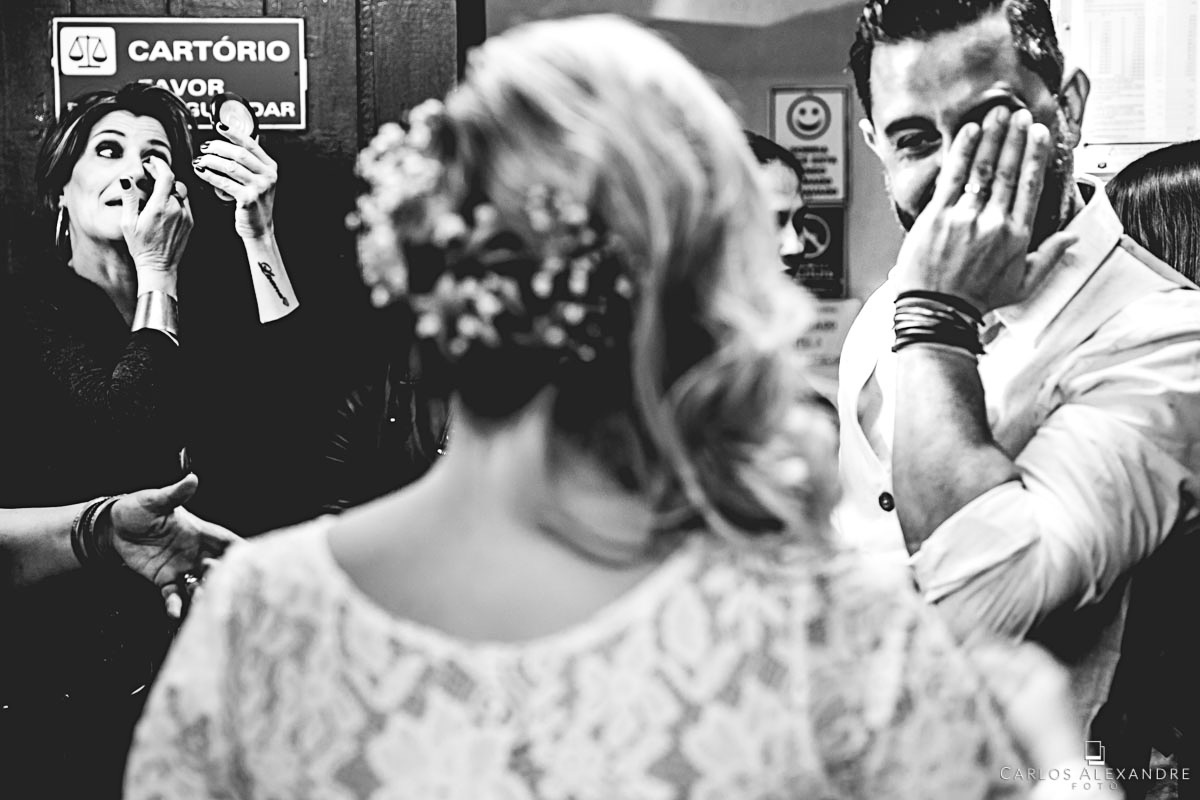 noivo e madrinha fazendo ações simultaneas chorando e retocando a maquiagem fotografo de casamento três corações mg carlos alexandre foto casamento em são thomé das letras sul de minas