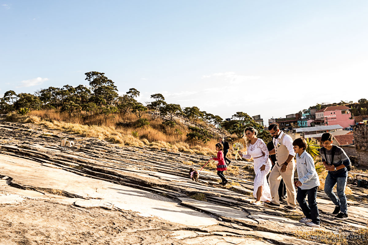 noivos e convidados subindo a montanha após a emoção  fotografo de casamento três corações mg carlos alexandre foto casamento em são thomé das letras sul de minas