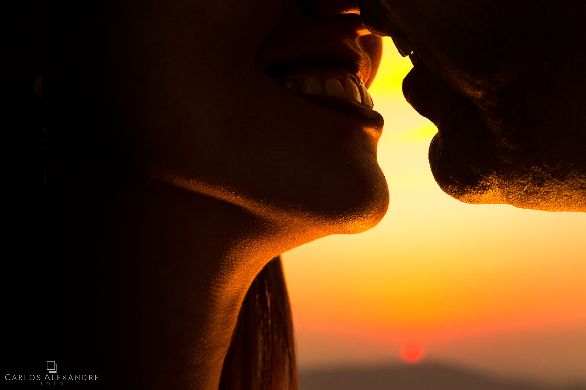lindo beijo com amor e paixão do casal de namorados ao por do sol ensaio pré casamento fotografo carlos alexandre foto tres corações lambari