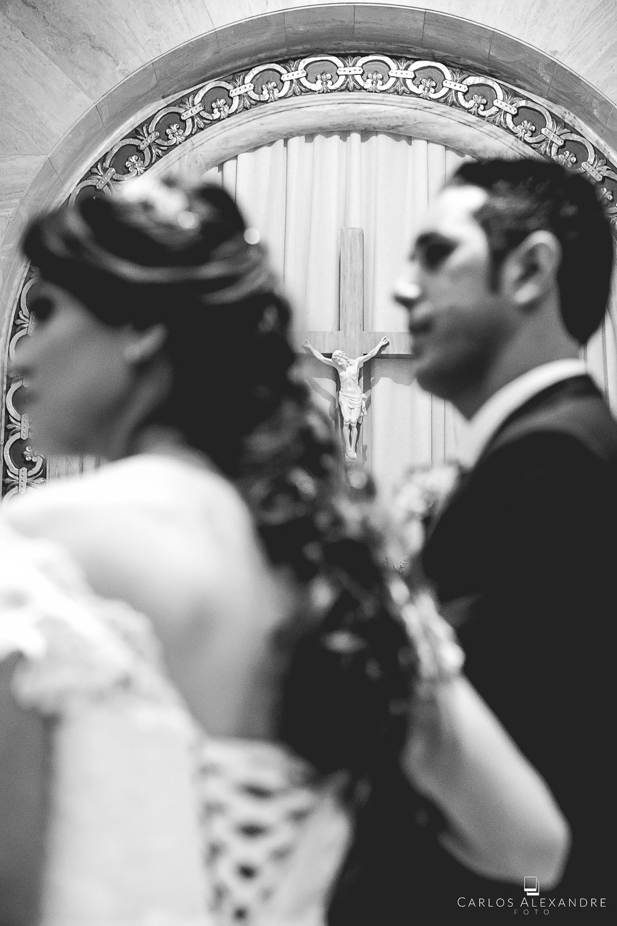 jesus na cruz na igreja ao fundo com o casal casamento em lambari fotografado pelo fotografo de casamentos de três corações carlos alexandre foto