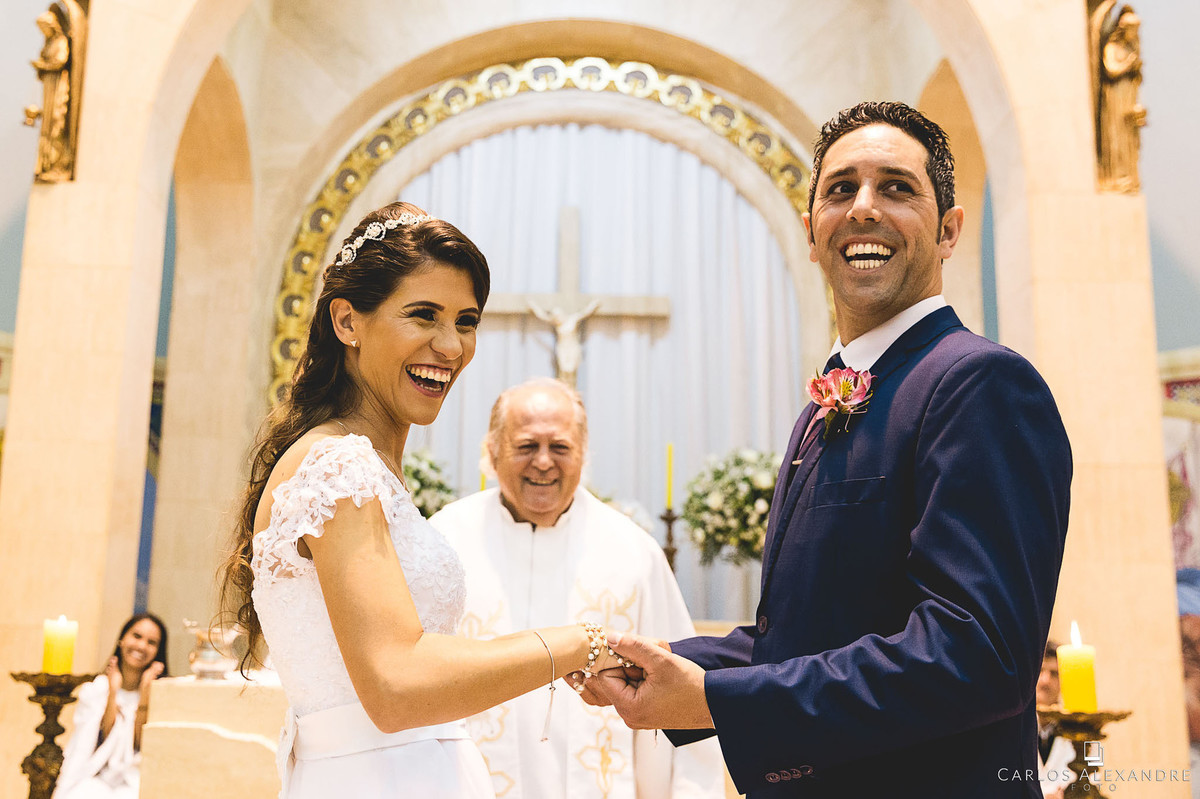 noivos e padre dando risada durante o casamento casamento em lambari fotografado pelo fotografo de casamentos de três corações carlos alexandre foto