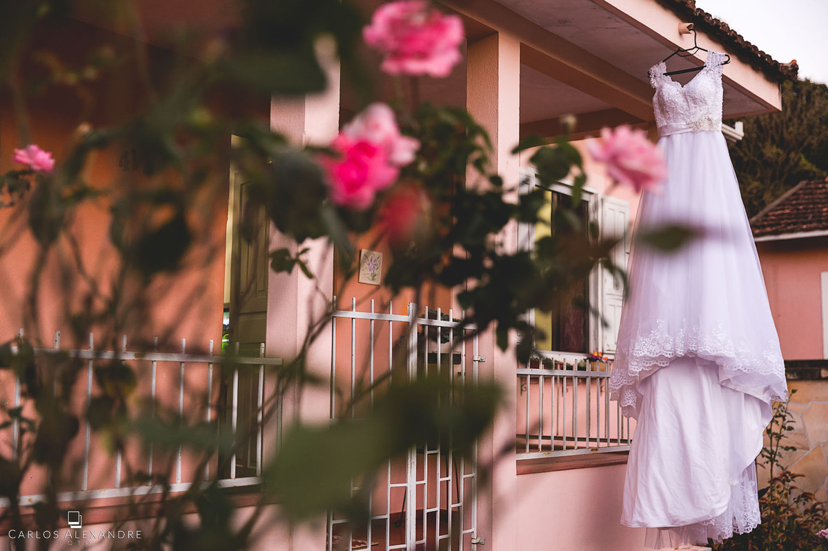 vestido de noiva pendurado com flores casamento em lambari fotografado pelo fotografo de casamentos de três corações carlos alexandre foto