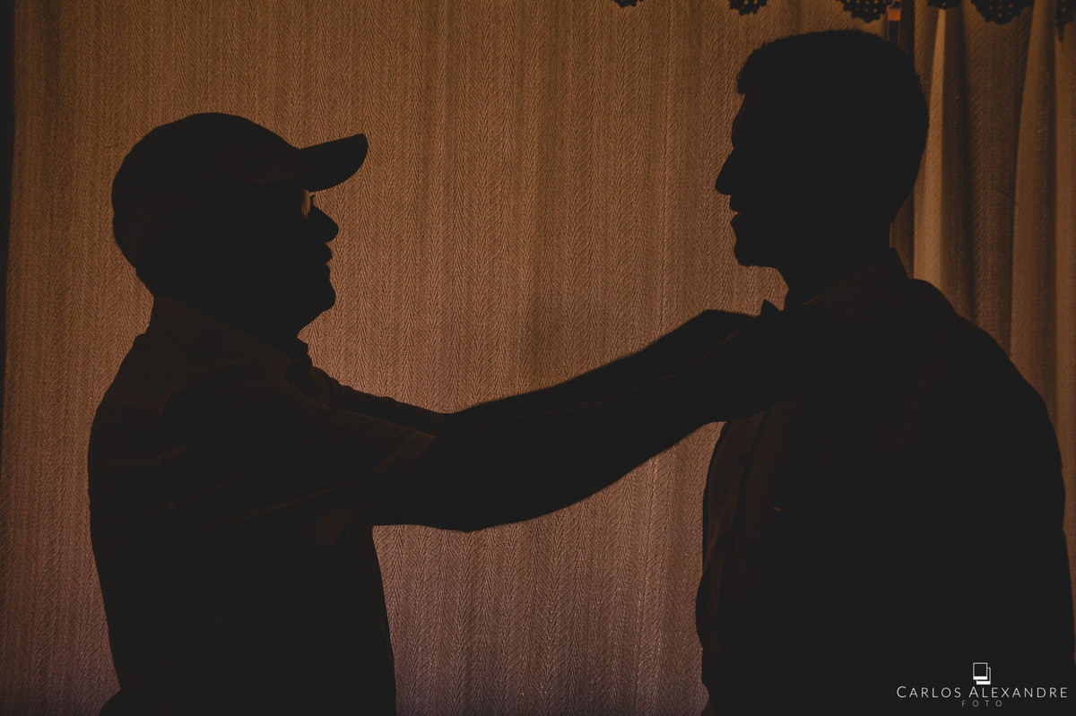 pai arrumando a gravata do filho noivo casamento ao ao livre em varginha fotografado por carlos alexandre foto fotografo de casamento em três corações