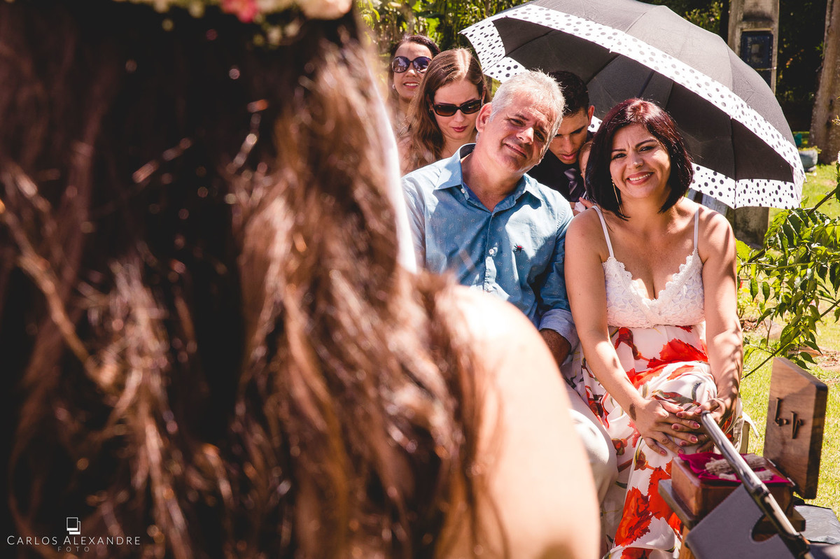pais da noiva sorrindo emocionados ao verem sua filha casar
