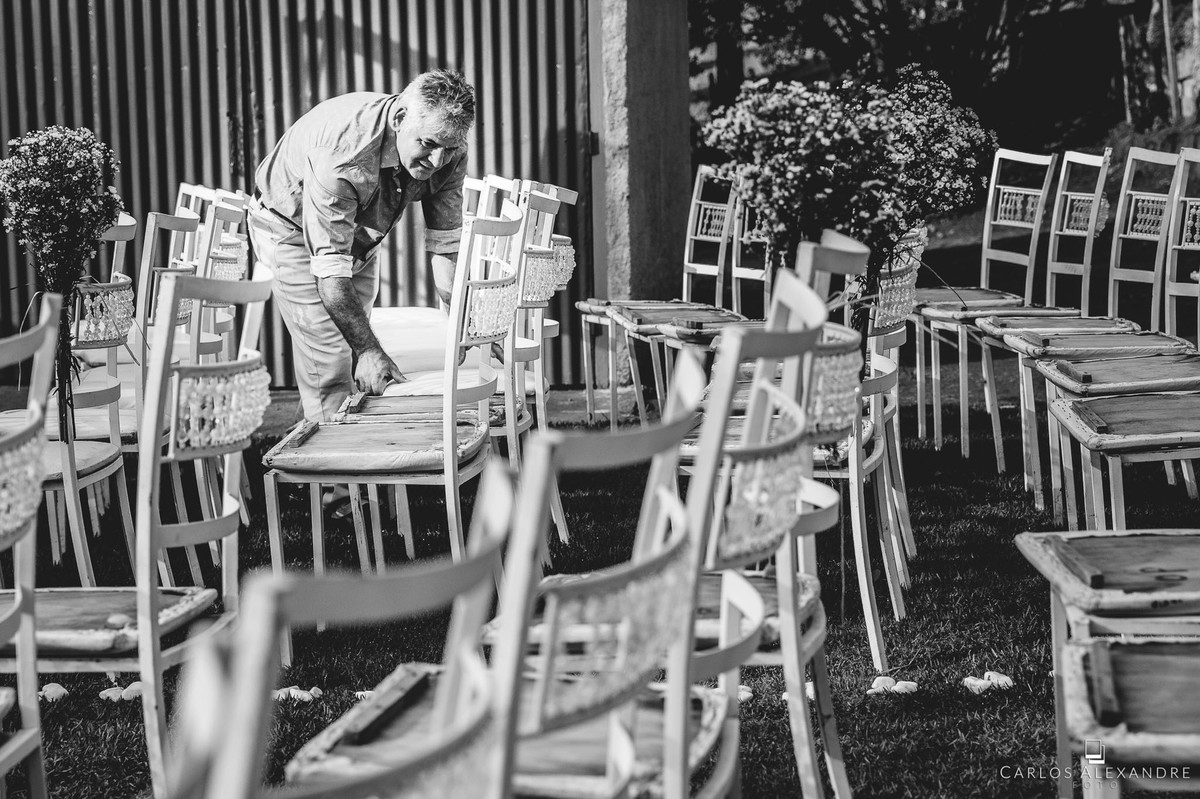 pai da noiva finalizando os detalhes da decoração casamento ao ao livre em varginha fotografado por carlos alexandre foto fotografo de casamento em três corações