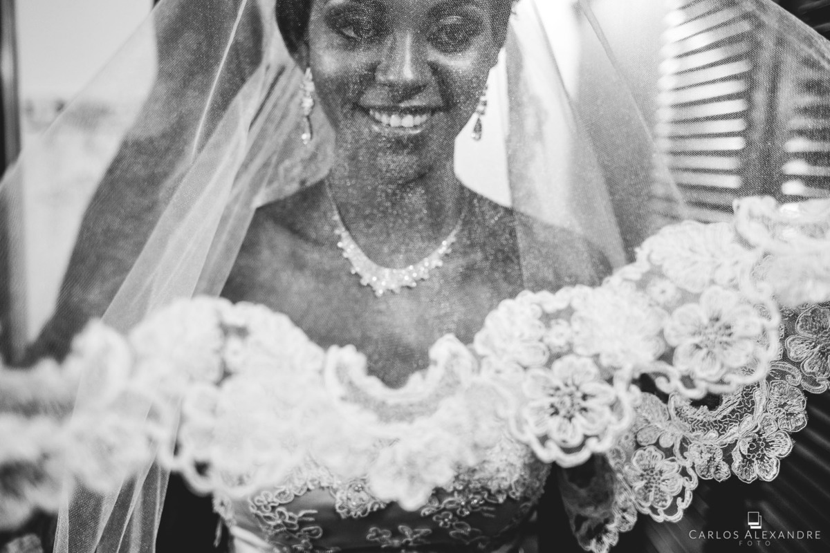 magnífico véu de noiva afrodescendente sendo colocado, com belo sorriso de dentes brancos