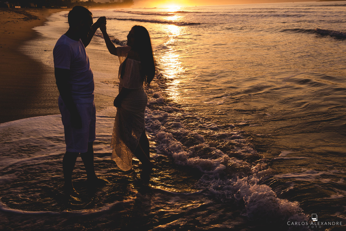 casal dançando e girando dançando valsa descalços à beira do mar