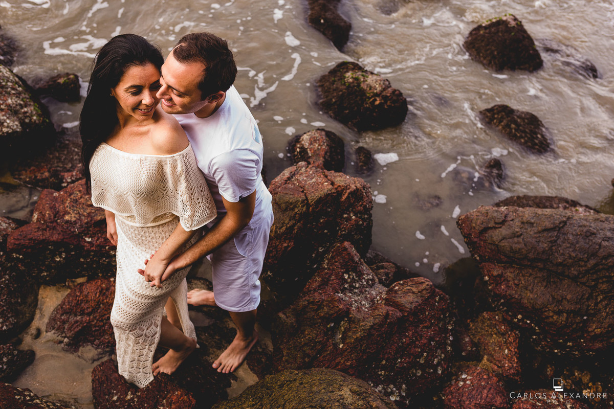 aquela vibe apaixonante de dois seres que são apaixonados entre si á beira do mar com as ondas calmas envolvendo as rochas ao seu redor