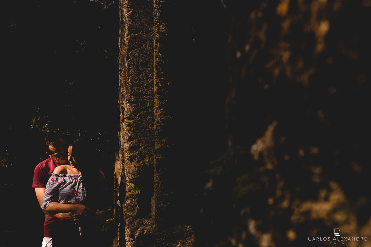 outra bela foto nas ruínas, com sol cortando e iluminando alguns elementos dos rostos do casal
