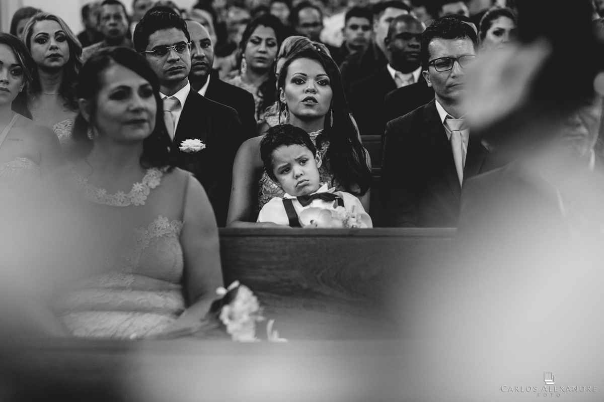 menininho de saco cheio e emburrado, com o casamento ocorrendo e ele querendo ir embora, fotógrafo de casamentos Carlos Alexandre Fotografia Três Corações MG