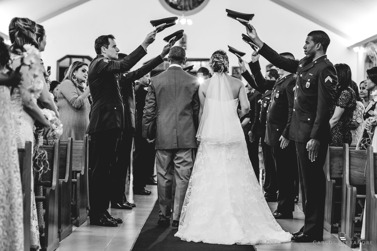 saída em preto e branco dos noivos com a guarda de honra os saudando, fotógrafo de casamentos Carlos Alexandre Fotografia Três Corações MG
