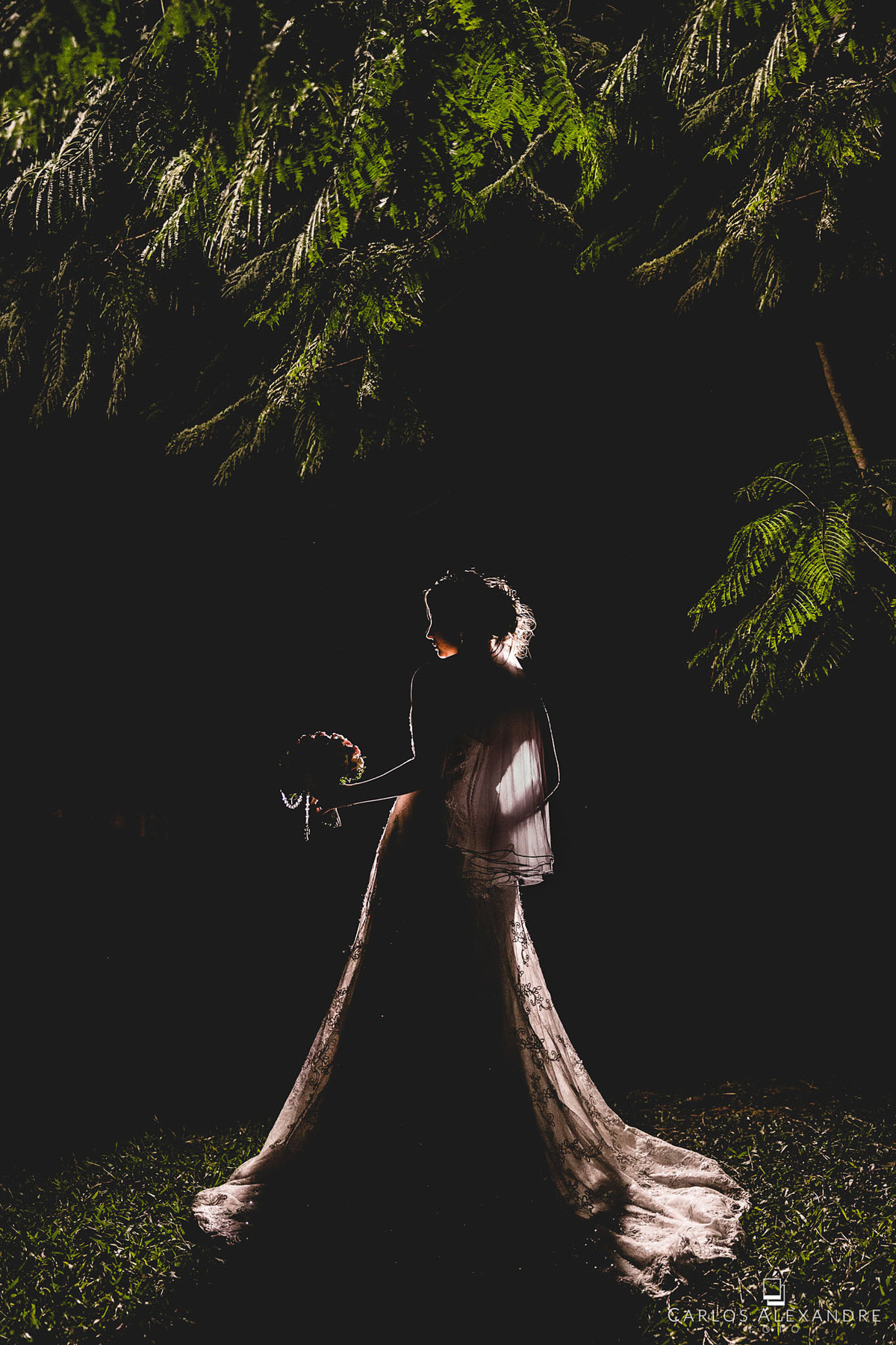 retrato de noiva de costas mostrando somente sua silhueta no contra luz, segurando o buquê, fotografado por carlos alexandre, da cidade de 3 corações, e sul de minas