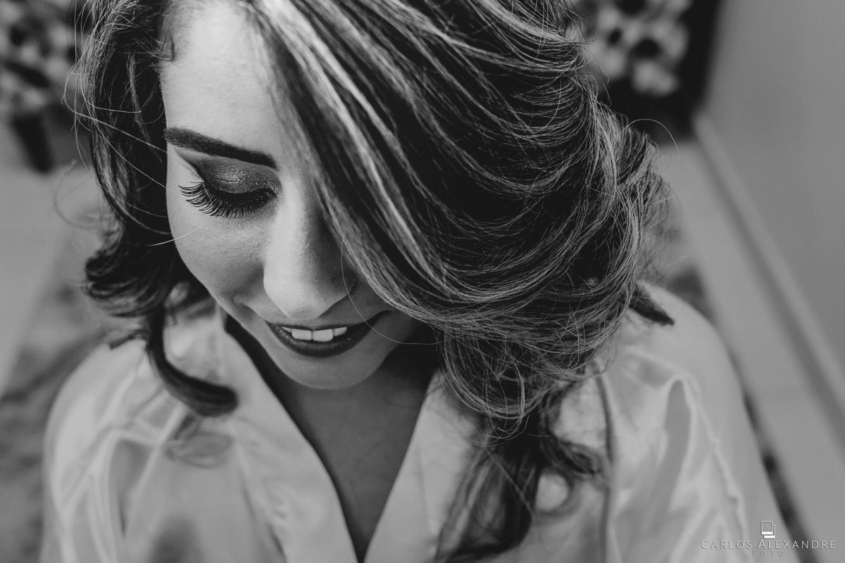 fotografia fetia de um ângulo superior onde vemos os cílios e o singelo sorriso da noiva, fotógrafo de casamentos Carlos Alexandre Fotografia Três Corações MG