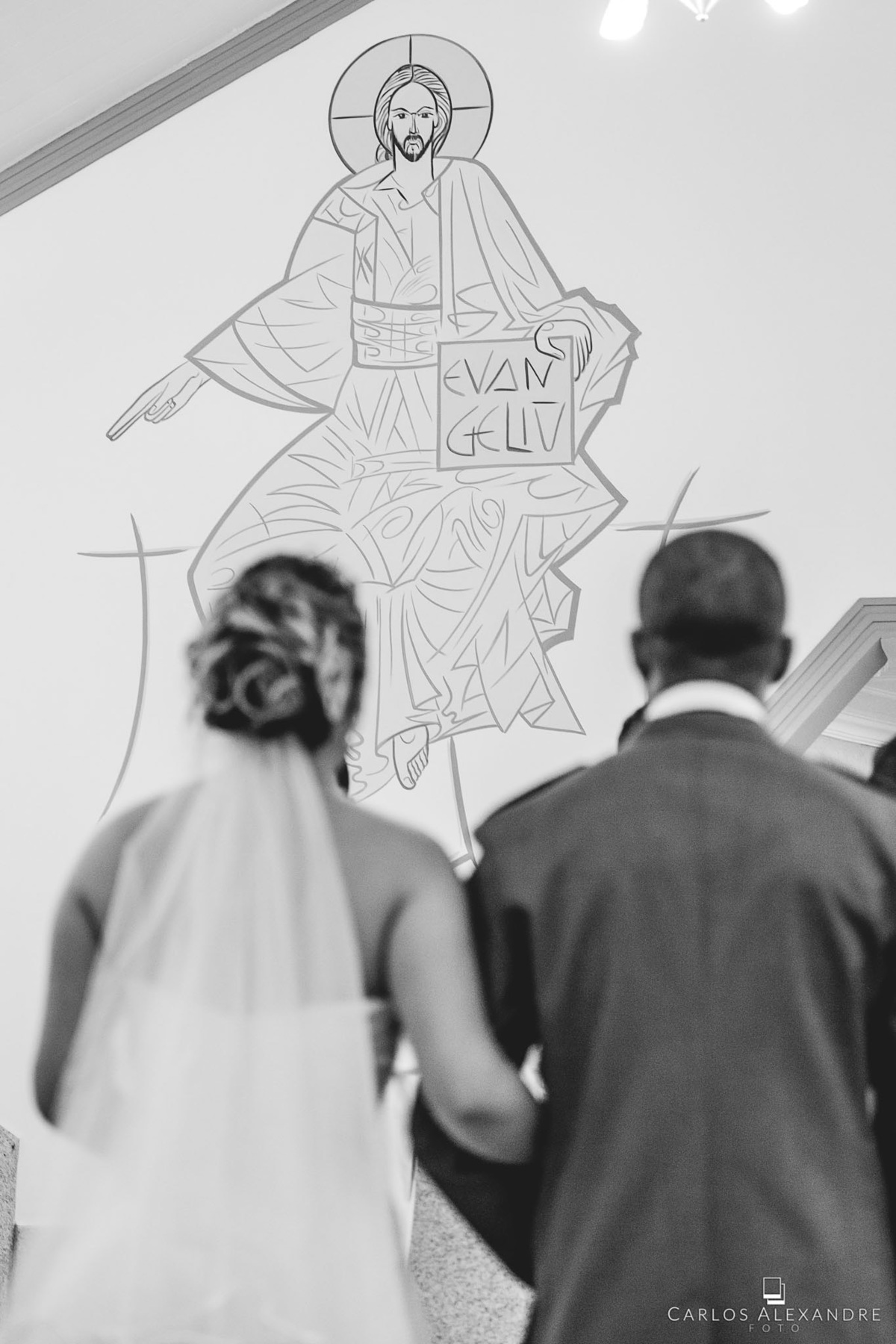 pintura de jesus na parede abençoando o casal que está se casando, fotógrafo de casamentos Carlos Alexandre Fotografia Três Corações MG