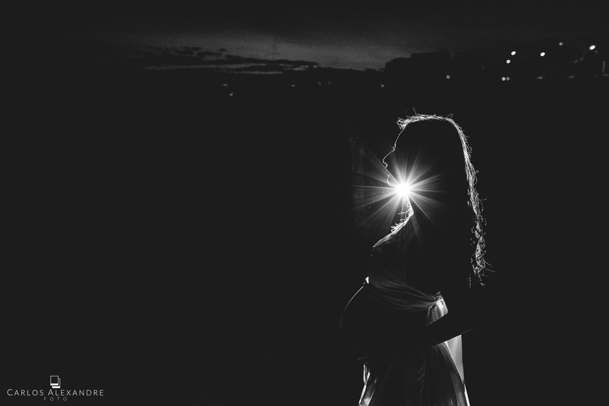 contra luz noturno com a silhueta da mão ainda gestante, fotografia de grávida carlos alexandre foto tres coracoes sul de mg