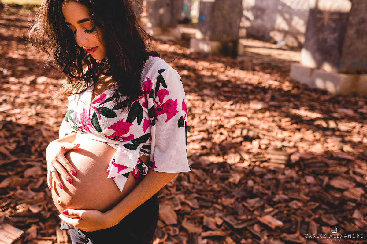 gestante com a mão na barriga sente sua filha e se conecta com o bebê antes de nascer, pelo fotógrafo de gestantes de três corações carlos alexandre foto