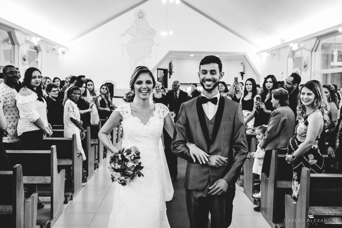 noivos saindo da igreja todo contentes e sorridentes pelo casamento, foto carlos alexandre 3 corações minas gerais