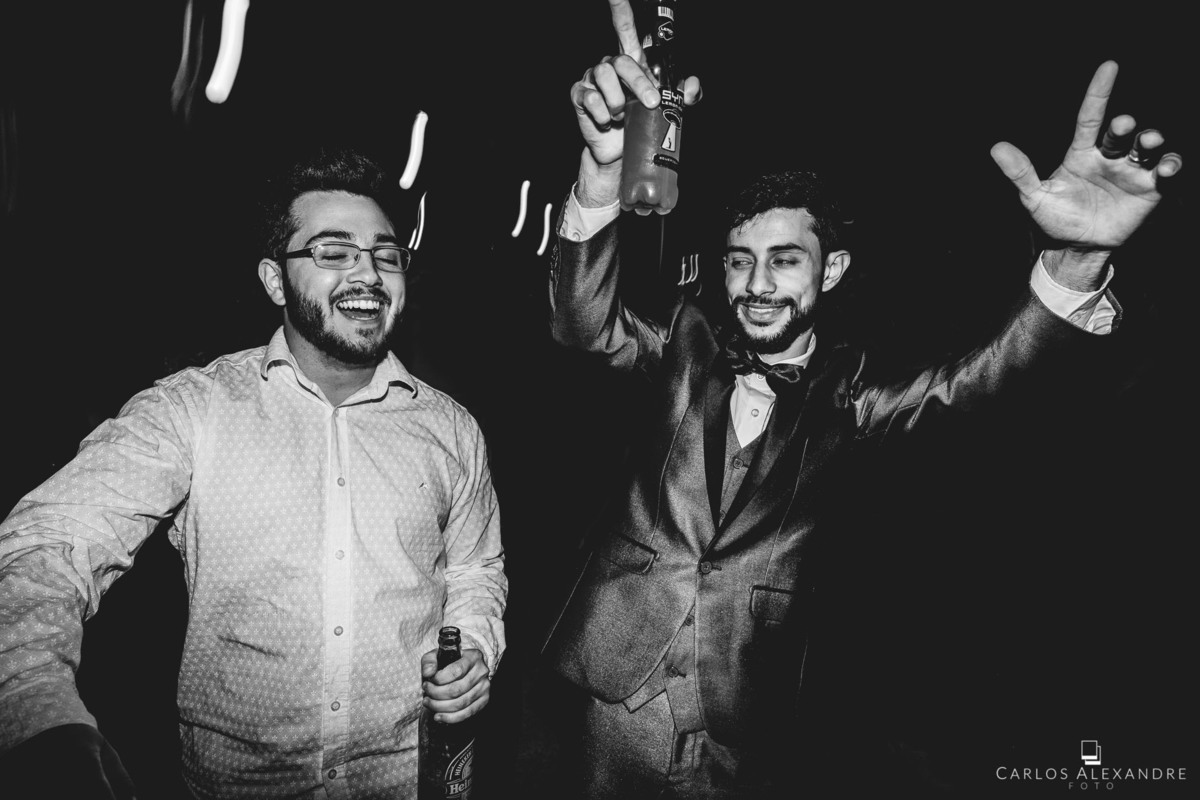 convidado ilustre todo feliz e agitado com o noivo com as mãos para cima feliz demais, fotos de casamento por carlos alexandre fotografia