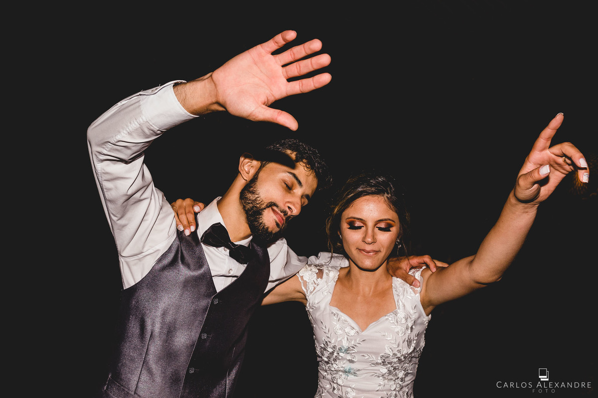 noivos abraçados dançam ao fim de sua animada festa de casamento, melhor fotógrafo de casamento carlos alexandre foto tres coraçoes mg