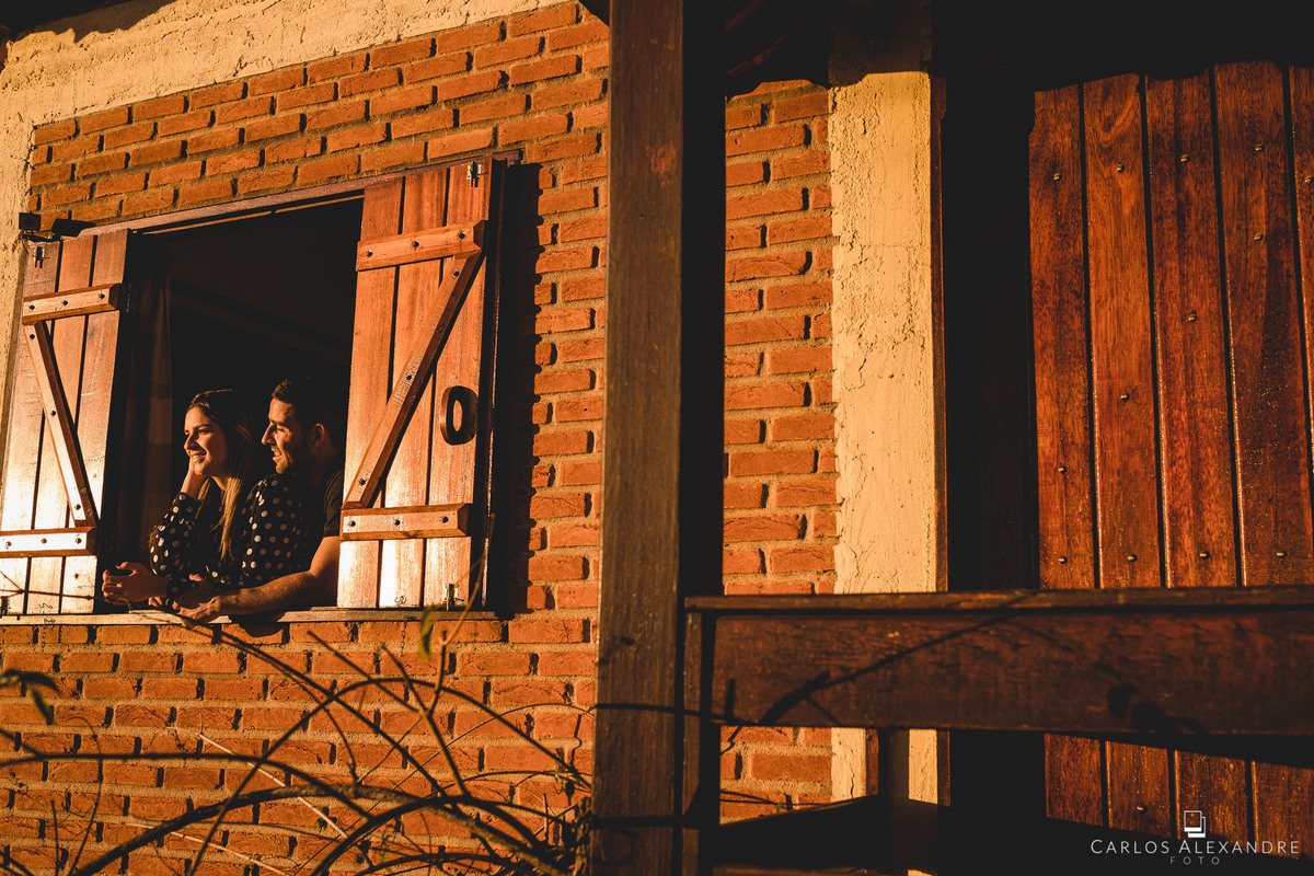 casa formidável em são tomé com o casal sentindo a vibe na janela da varanda fotos pré wedding em são thomé das letras, carlos alexandre fotografo de três corações mg