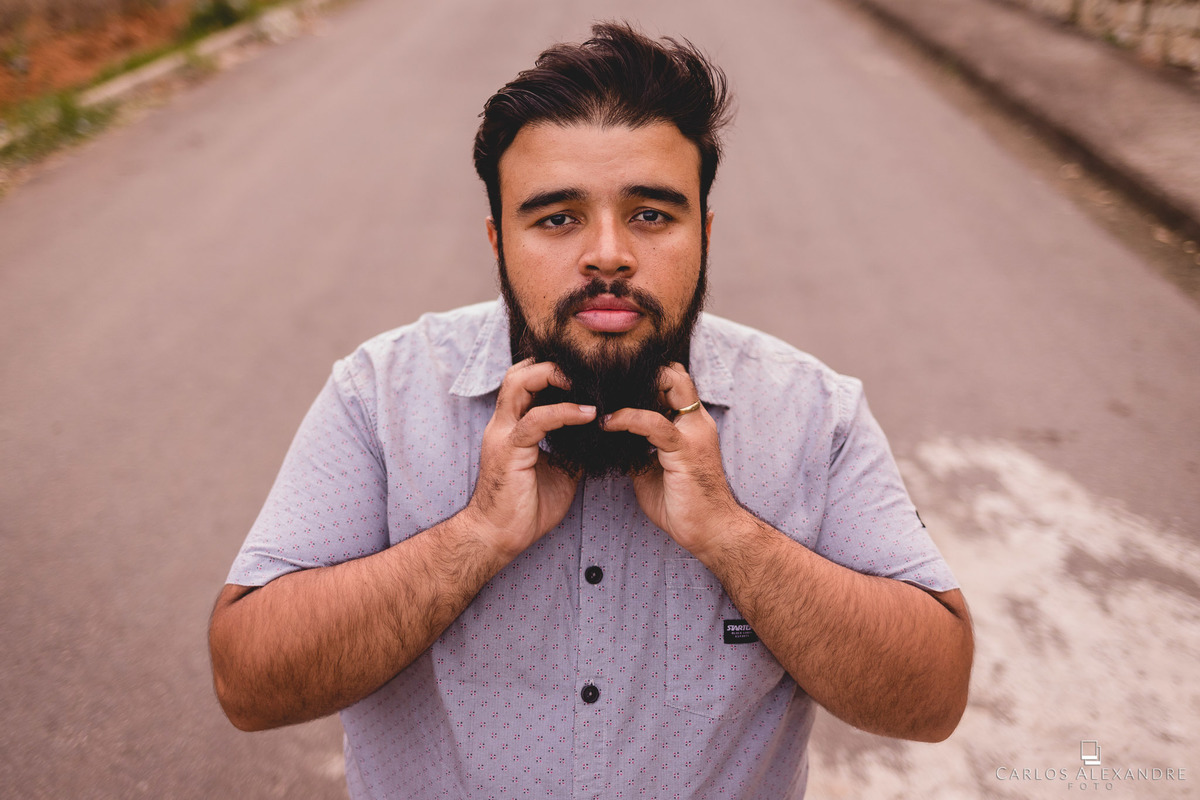 namorado barbudo mexendo em sua barba no meio da rua, recebendo boas energias , ensaio de fotos de casal fotografado por carlos alexandre foto tres corações mg