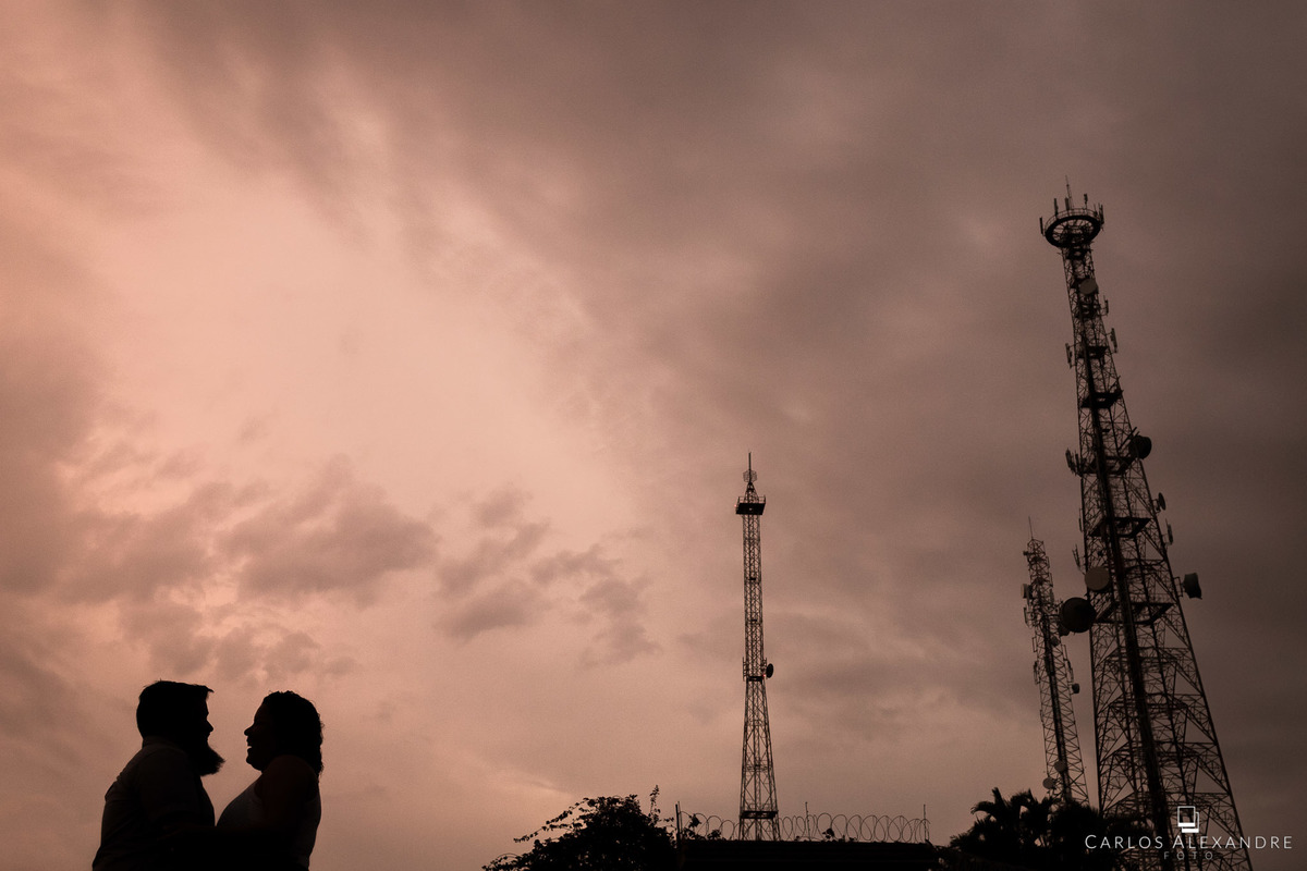 lindo contra luz com o casal em um dos pontos mais altos da cidade, com as torres de comunicação ao fundo, fotos de gordinhos pre wedding carlos alexandre fotografo de casamento