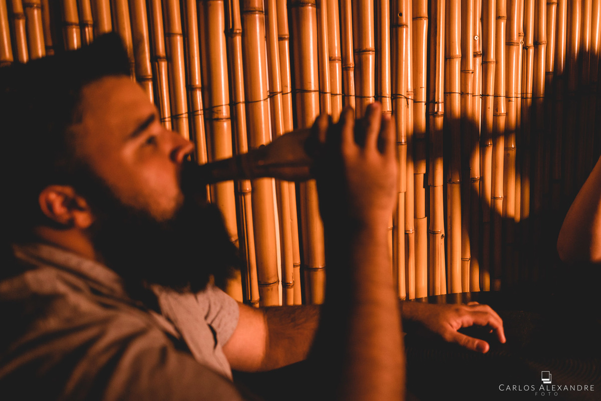 retrato do casal com sombra, onde o rapaz toma sua cerveja e sua namorada também e aparece em sua sombra, sessão de fotos em um sushi da bru tres corações MG sul de minas carlos alexandre foto