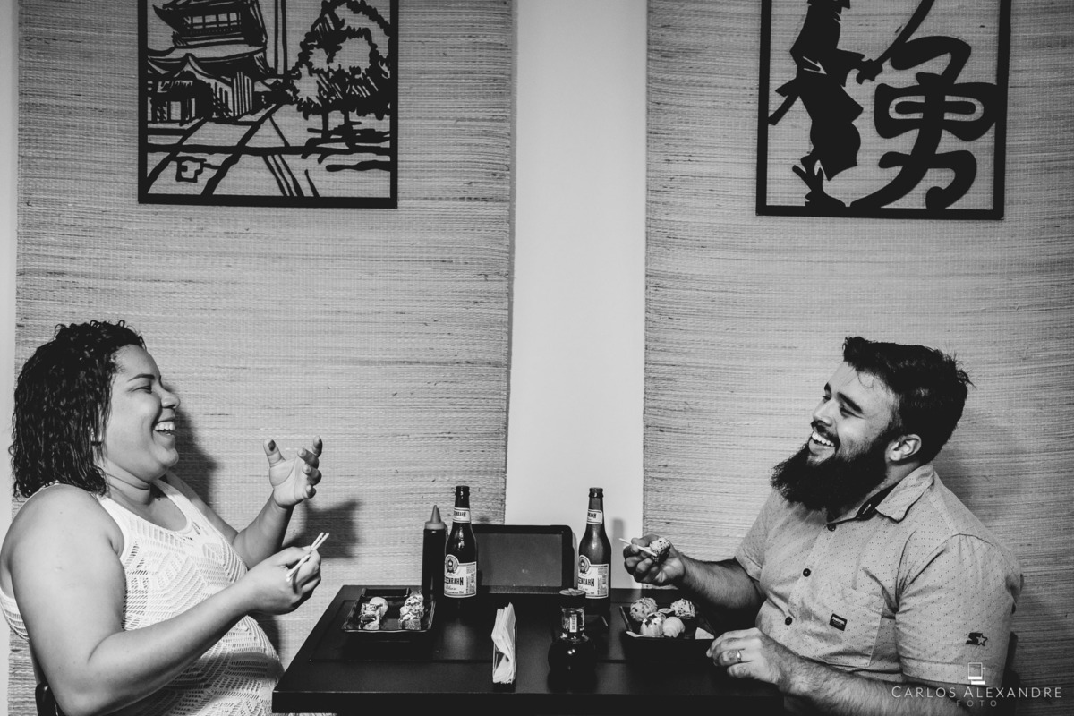 ensaio de casal comendo sushi, comida japonesa e dando risada feliz da vida, sessão de fotos em um sushi da bru tres corações MG sul de minas carlos alexandre foto