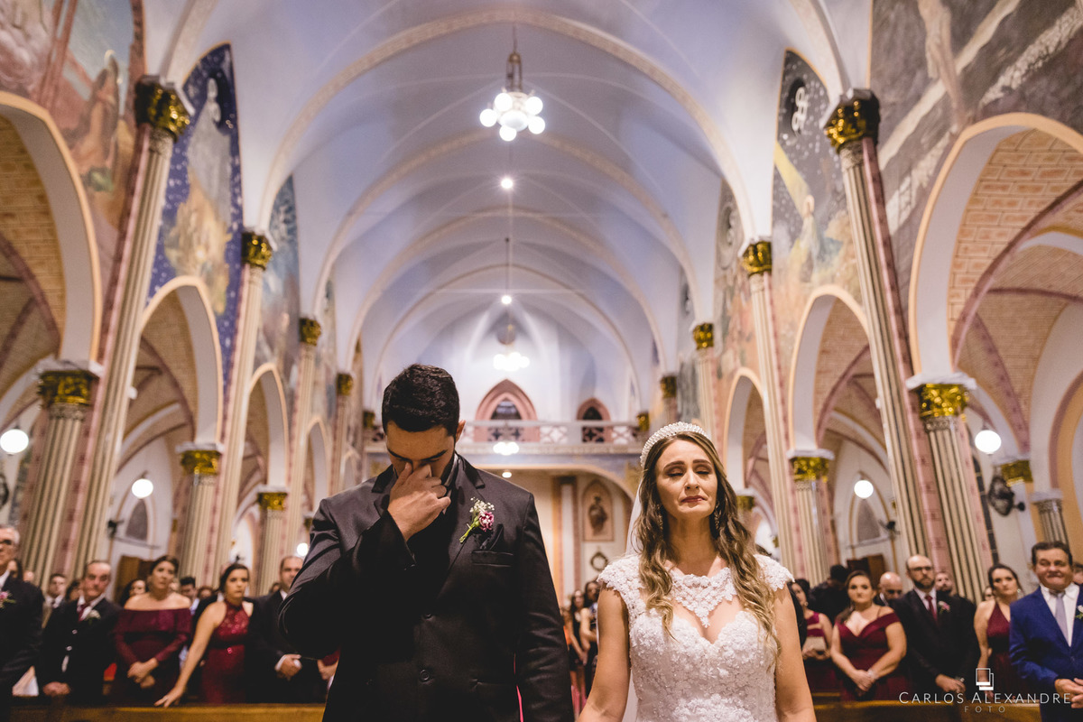 noivos emocionados orando e pedindo proteção assim como todos os convidados, casamento na igreja matriz sagrada família de três corações mg depois da reforma, fotos de casamentos carlos alexandre 