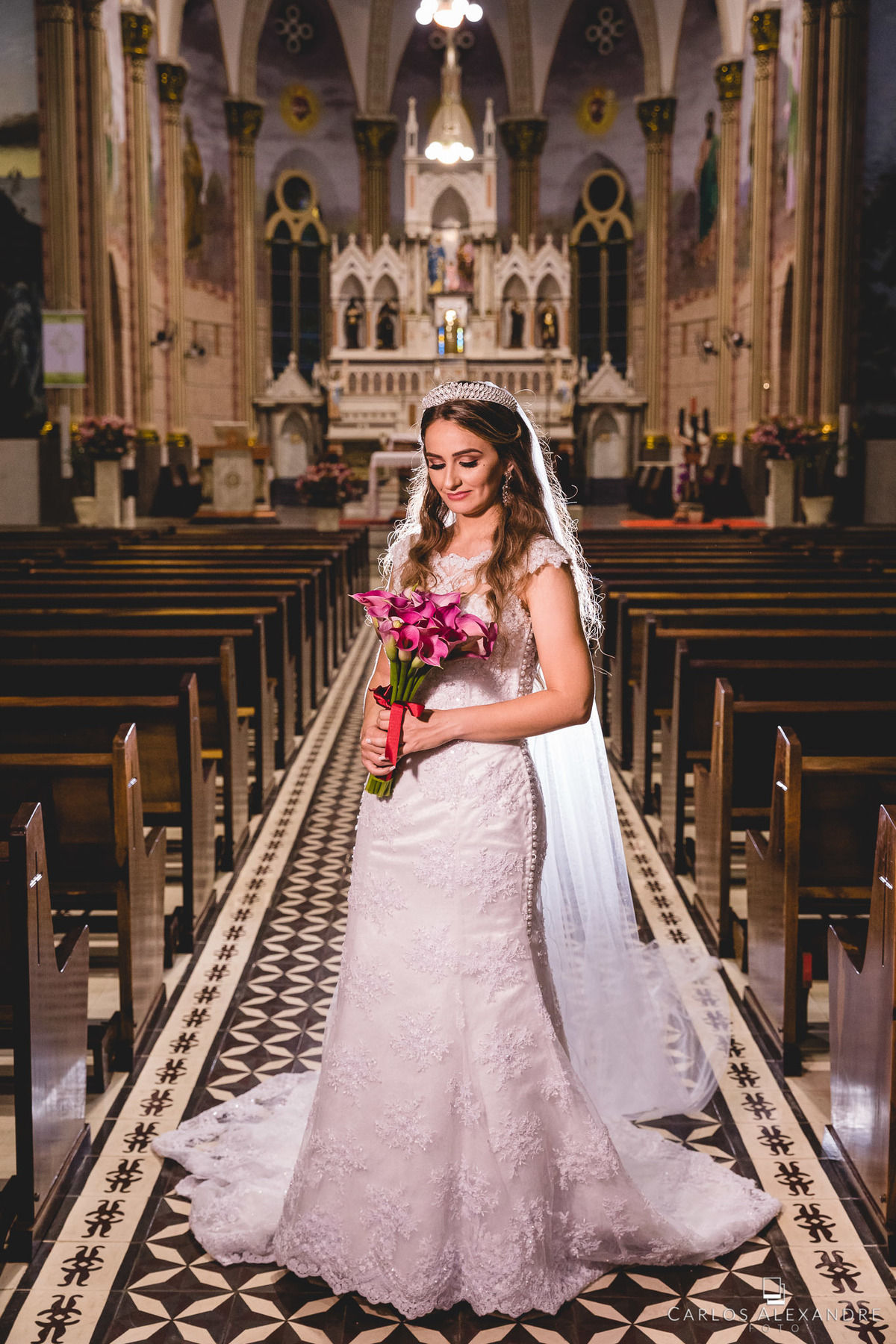 belo retrato da noiva na igreja segurando o seu buquê com seu véu caindo, casamento na igreja matriz sagrada família de três corações mg depois da reforma, fotos de casamentos carlos alexandre 