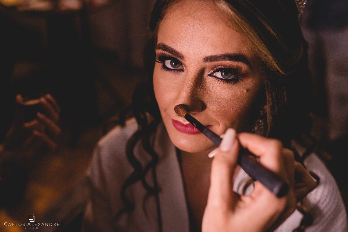 fortíssimo olhar da noiva enquanto retoca a sua maquiagem, fotos de making of da noiva no salão da cidinha reis, fotos de casamento em tres coracoes sul de minas carlos alexandre foto