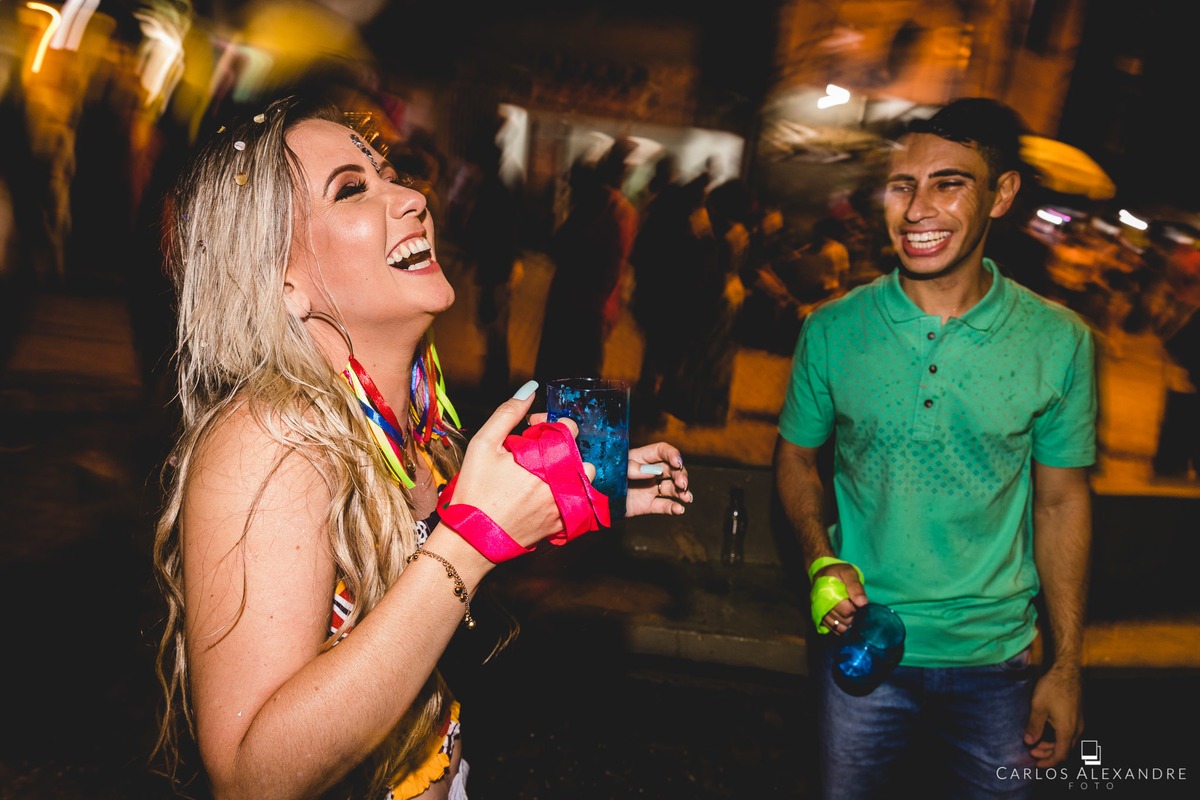 casal separado dando risadas e se divertindo ouvindo marchinhas 
, fotos de ensaio pré wedding no carnaval de lambari fotógrafo de casamento carlos alexandre foto em lambari três corações sul de mg 