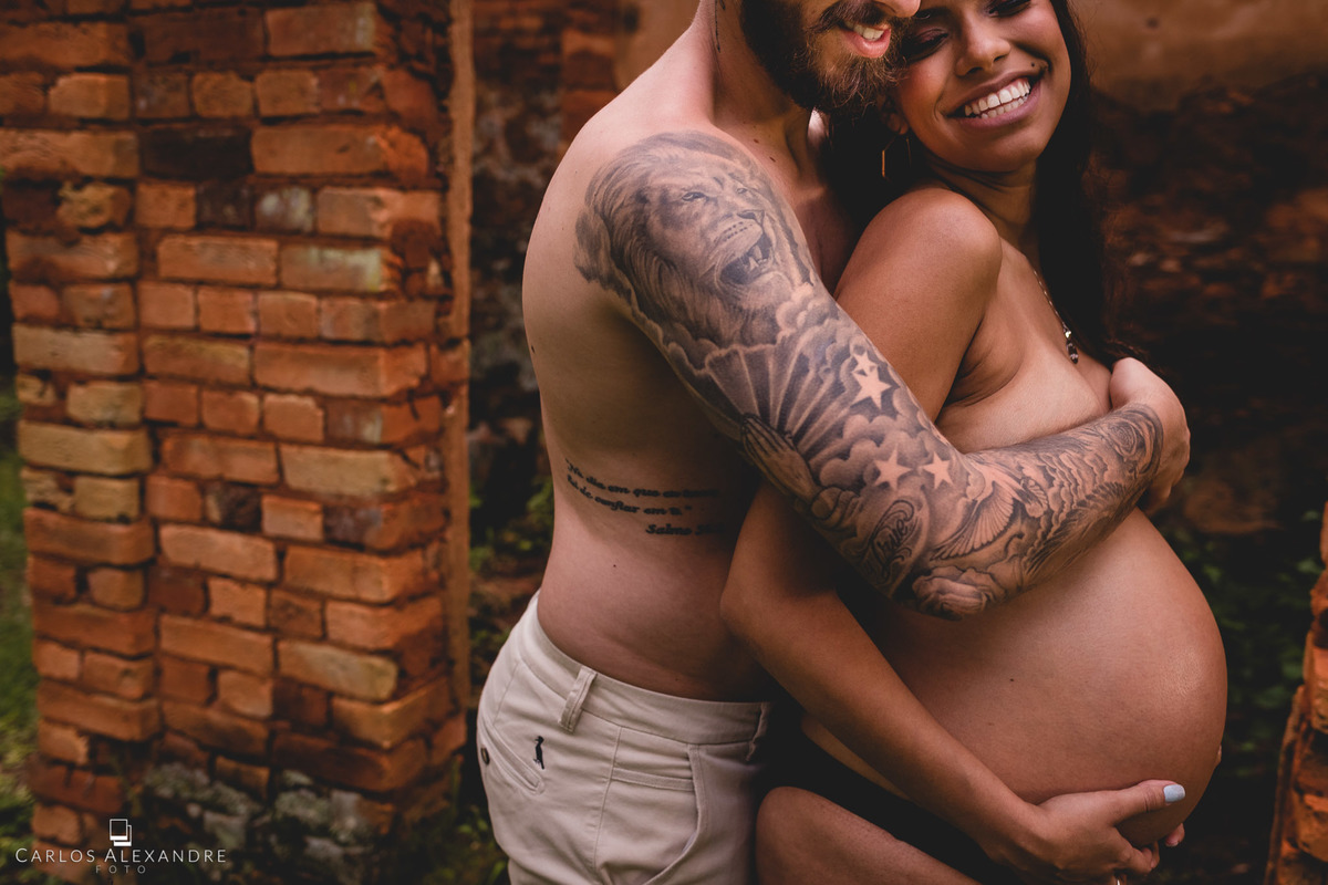 casal de namorados despidos segurando os seios e sorrindo pra vida fotógrafo de gestante em três corações mg carlos alexandre fotos em fazenda cachoeira