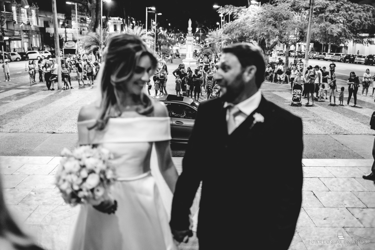 noiva com seu pai prestes a entrar na igreja com o pessoal na praça curiosos admirando a noiva, na matriz catedral metropolitana de pouso alegre, fotógrafo de casamentos carlos alexandre de três corações mg sul de minas