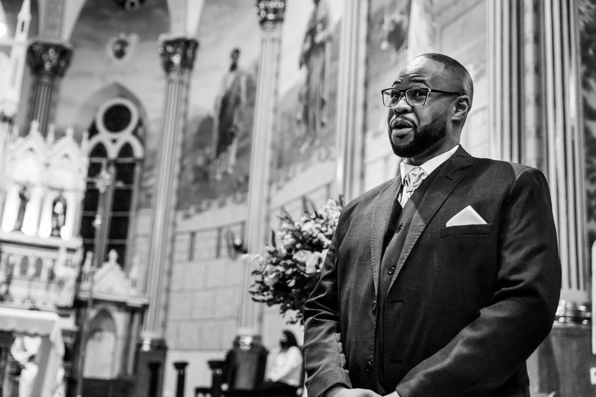 casamento na igreja matriz sagrada família em três corações mg fotografo de casamentos carlos alexandre foto noivo negro cheio de expressões brincando com os convidados antes da grande entrada 