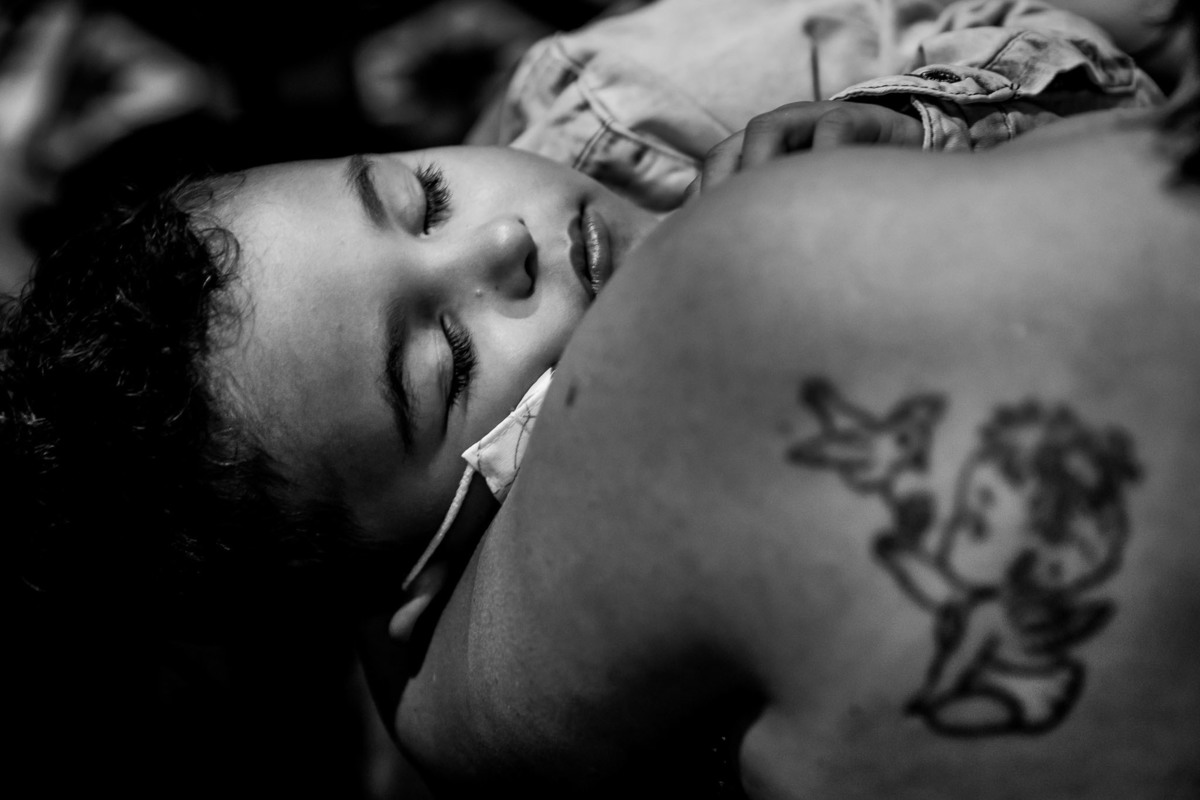 cerimônia de casamento na igreja matriz de três corações mg carlos alexandre fotógrafo criança de colo dormindo na cerimônia do casamento com uma tatuagem de anjinho ao lado transmitindo a paz do momento