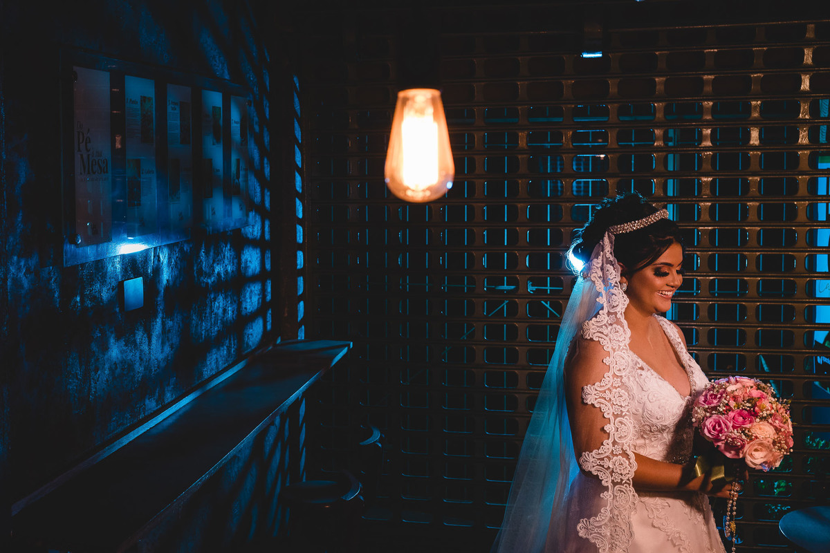 making of da noiva no salão spaço luz fotos por carlos alexandre e vestido lia noivas foto de noiva em um café com luz azul de recorte no portão de ferro e a noiva segurando o seu buquê com uma lâmpada retrô na frente