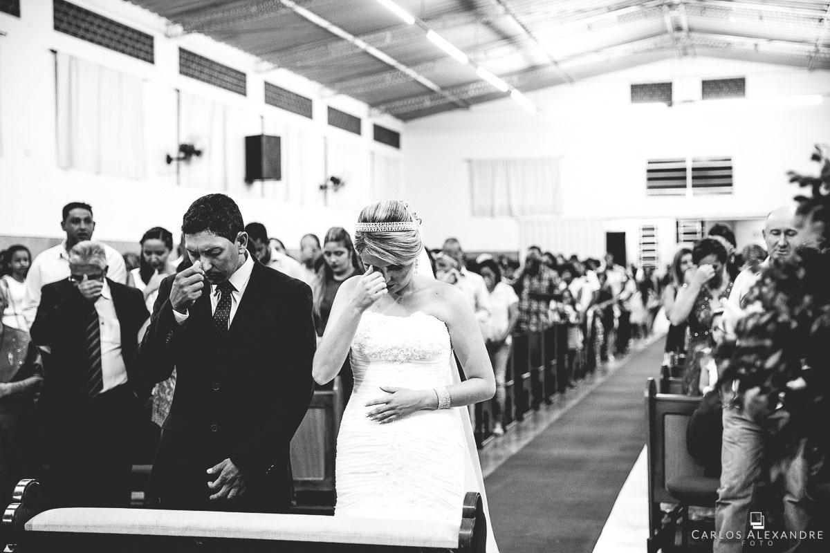 casal fazendo nome do pai no altar perante convidados e familiares