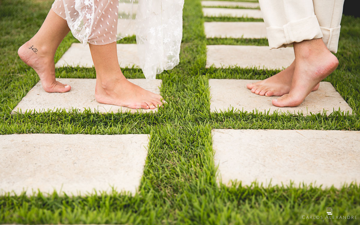casamento à luz do dia na grama em três corações, o casal está descalço e com roupas brancas na celebração e benção espírita