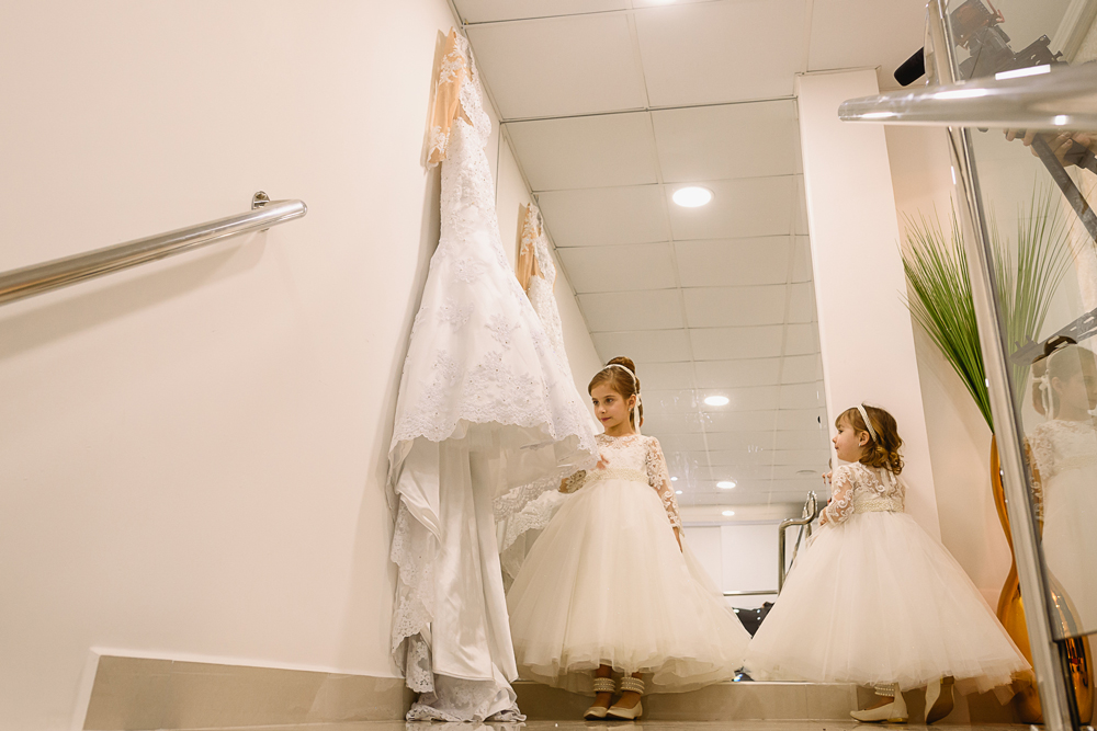 Filhas da noiva olhando para o vestido da mamãe