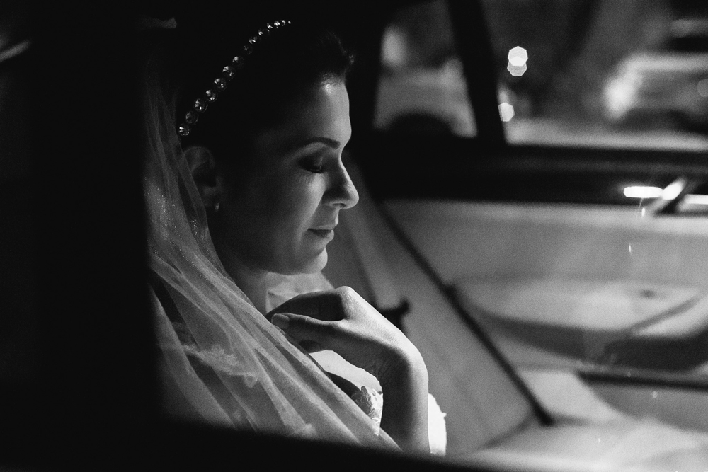 Noiva em um momento de reflexão dentro do carro enquanto aguarda seu momento de entrar na igreja