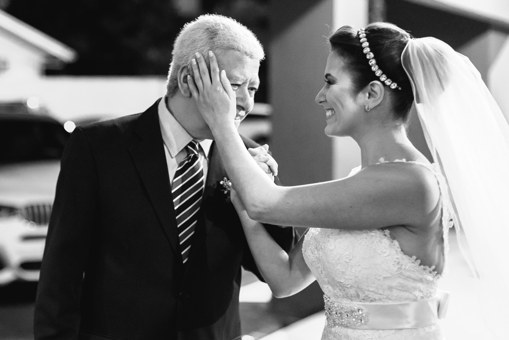 Noiva fazendo um carinho no rosto do seu pai antes de entrar na igreja