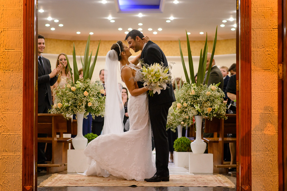 Noivos se beijando na saída da igreja