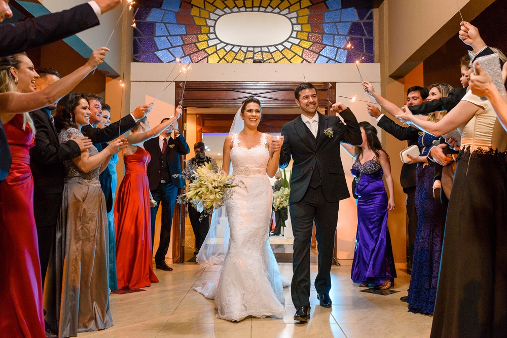 Noivos comemorando na saída do casamento